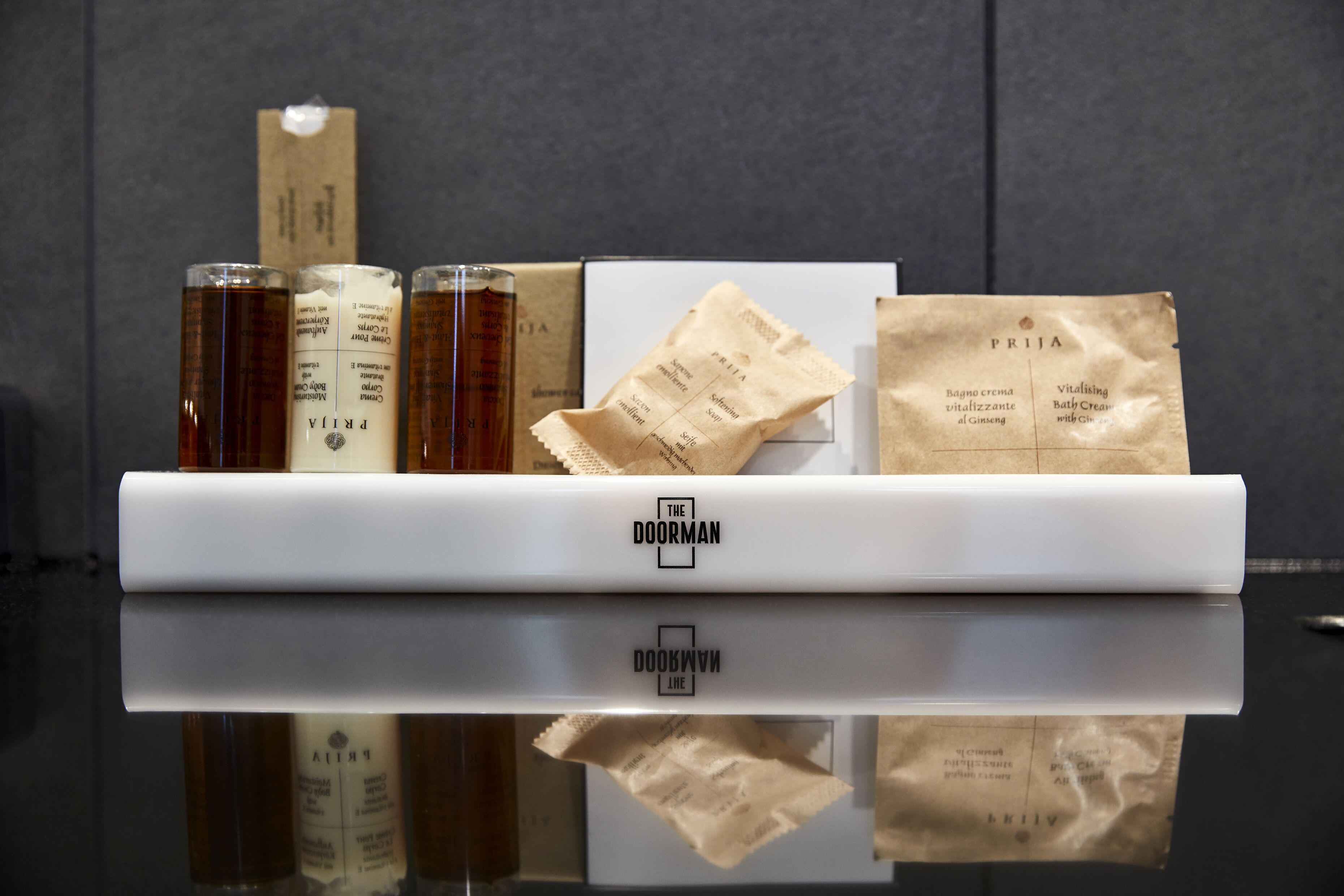 Een presentatie van diverse producten, waaronder flessen en papieren zakken met tekst, gerangschikt op een witte plank voor een donkere achtergrond.