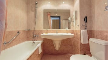 Un baño con bañera, lavamanos e inodoro.