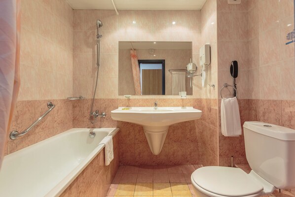 A bathroom with a bathtub, sink, and toilet. - Aquamarine Hotel (Nessebar)