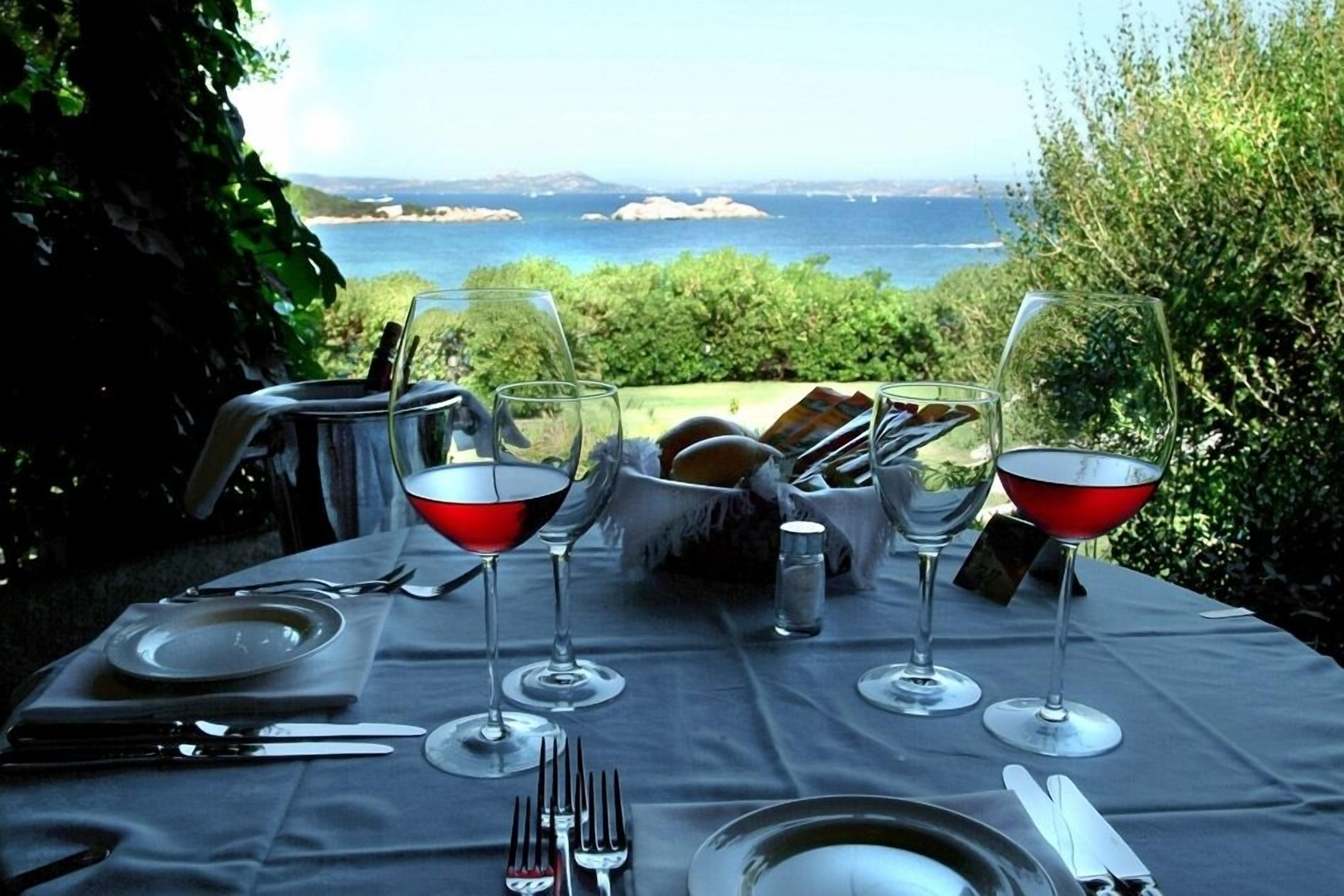 Una mesa lista para una comida con vista al mar.