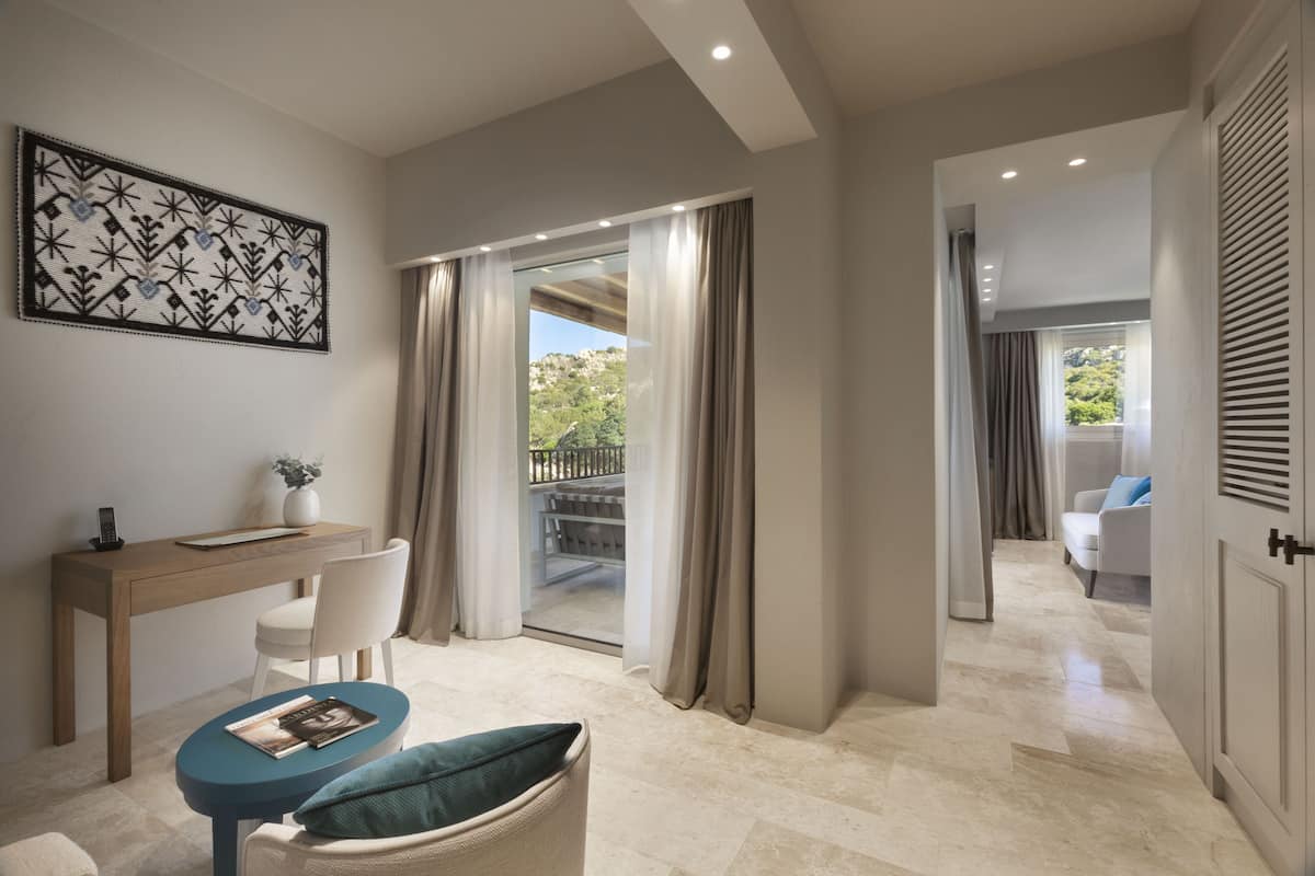 Habitación de hotel moderna con escritorio, silla y vistas al exterior.