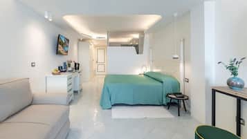 A modern bedroom with a bed, a sofa, a small table, and a desk.