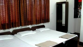 Una habitación de hotel con una cama grande, un armario y un espejo.