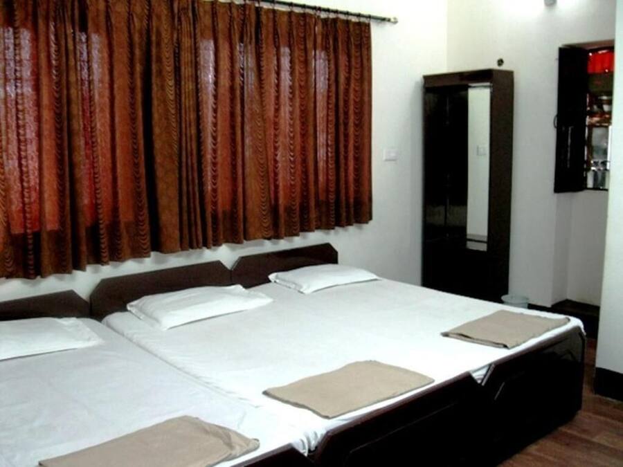 Una habitación de hotel con una cama grande, un armario y un espejo.