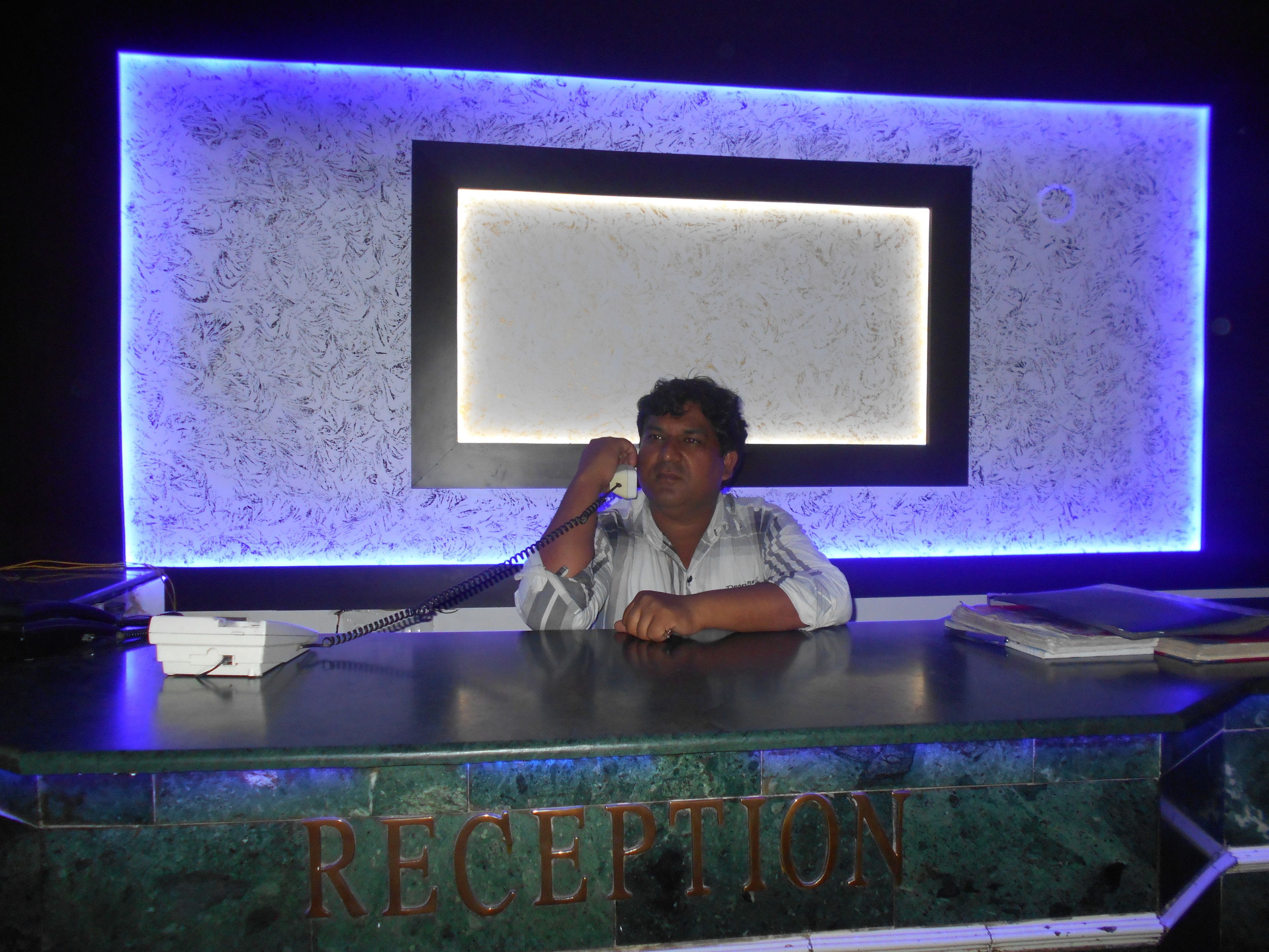 Uma mesa de recepção com uma placa que diz "RECEPTION" e um telefone.