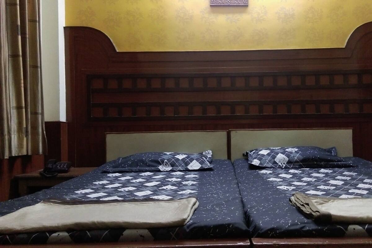 Ein Doppelbett mit Holz Kopfteil, zwei Kissen und einer Decke.
