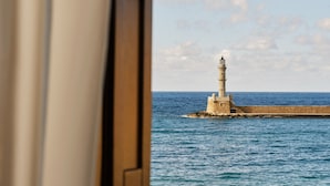 A lighthouse on a rocky outcrop in the sea, viewed from a doorway.