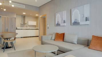 Un salon moderne comprenant un canapé, une table basse et un coin repas avec une chaise et une table.