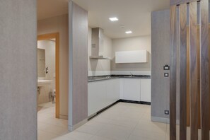 Een moderne keuken met witte kasten, een zwart aanrecht en een ingebouwde kookplaat.