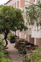 Un sendero que conduce a un edificio de fachada de ladrillo y múltiples ventanas.