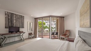 A hotel room with a large bed, a TV on a console table, a desk with a chair, and a balcony with a table and chairs. - Hotel Tropicana Pattaya (Pattaya)