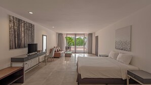 A modern bedroom with a large bed, a TV, a desk, and a balcony with curtains. - Hotel Tropicana Pattaya (Pattaya)