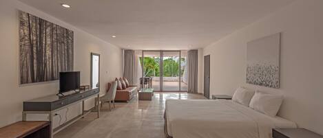 A modern bedroom with a large bed, a TV, a desk, and a balcony with curtains.