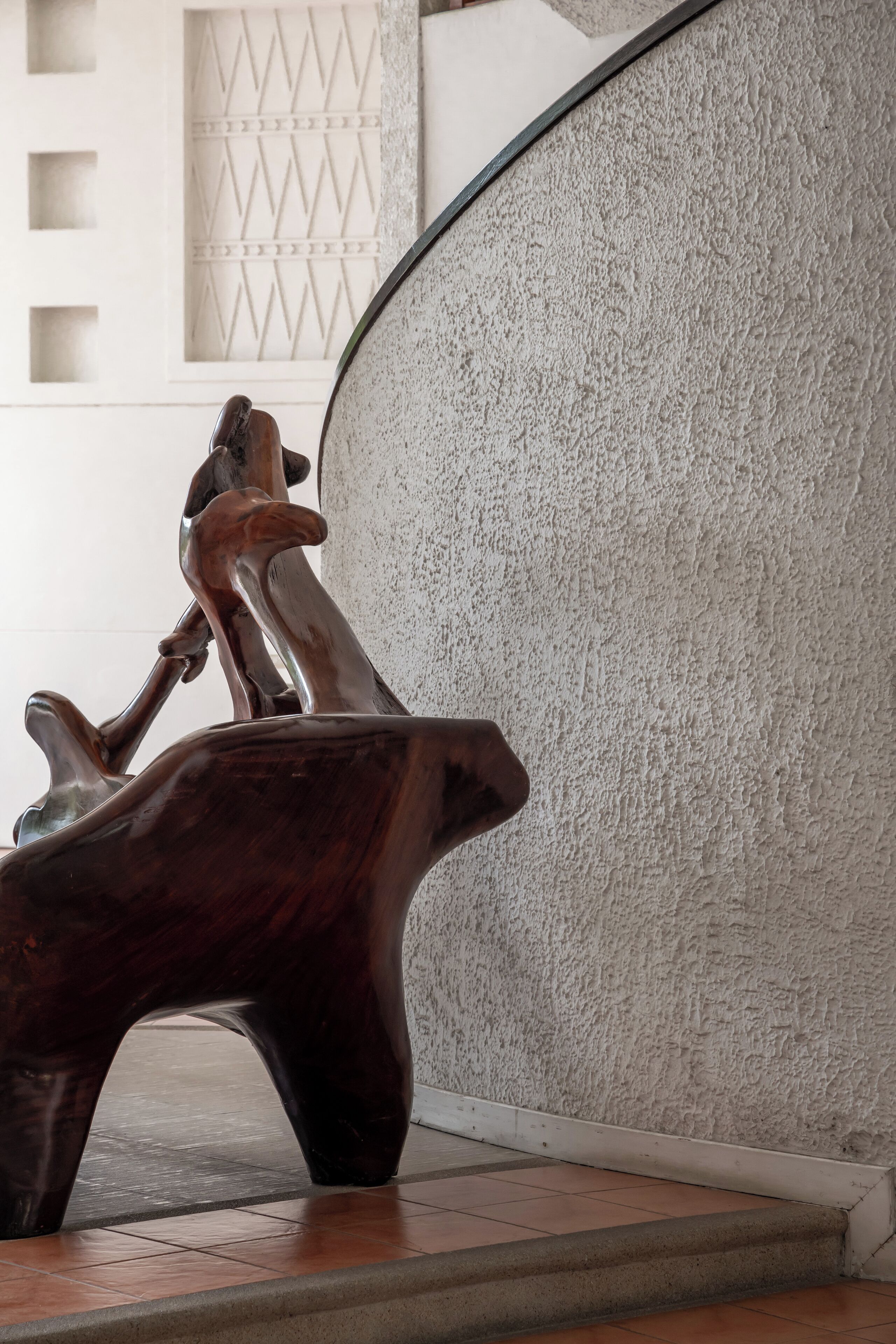 A wooden sculpture of a figure on a rock.