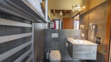 Un baño moderno con un espejo grande, un lavamanos y un inodoro.