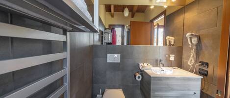 A modern bathroom with a large mirror, a sink, and a toilet.