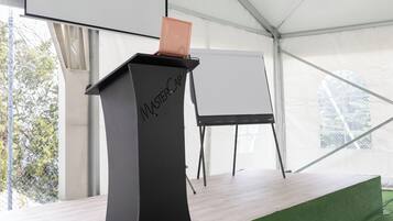 A tent with a podium labeled "MasterCap" and a blank projection screen.