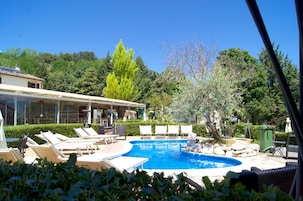 Una piscina al aire libre de temporada, sombrillas