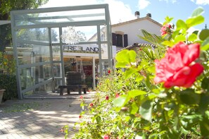 A glass structure labeled "FREE LAND" with a bench and potted plants outside. - La Valle Dei Caprioli - B&B (Montescudo)