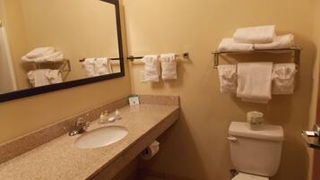A bathroom with a sink, mirror, towel rack, and toilet.