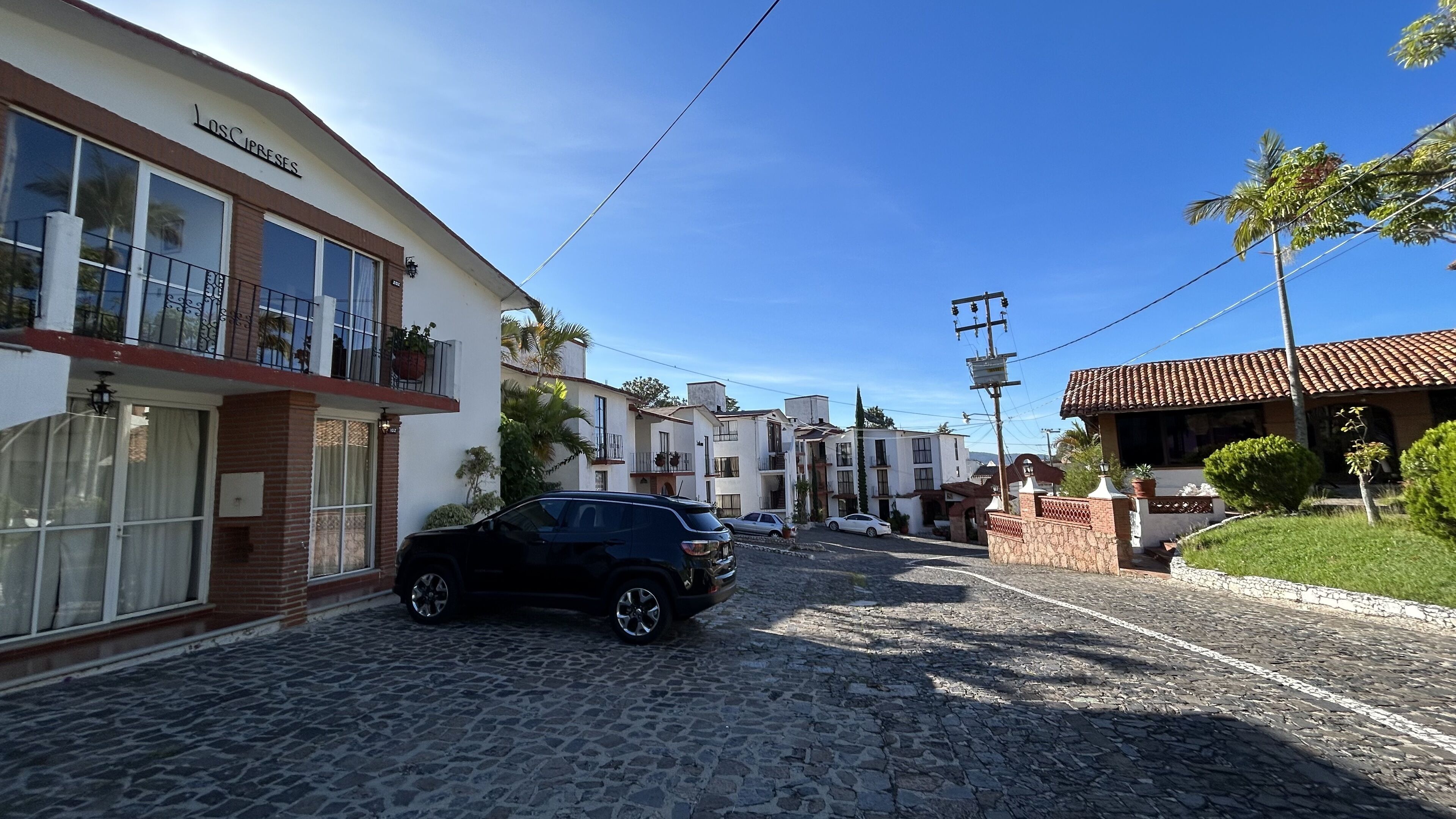 A cobblestone street lined with residential buildings, including a hotel with a balcony and a sign reading "LOSC PRESEAS".