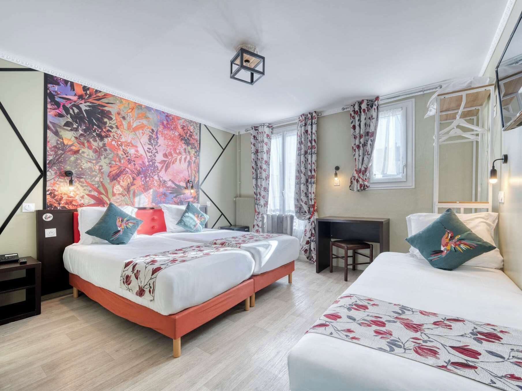 Una habitación de hotel moderna con una cama grande, un escritorio y un vibrante mural floral en la pared.