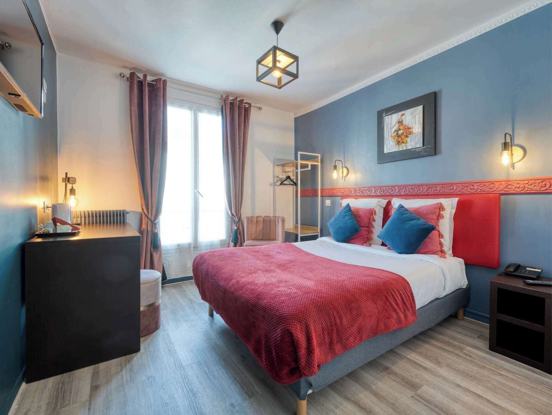 A modern bedroom with a large bed, a bedside table, a nightstand, a radiator, a wardrobe, and a window with curtains.