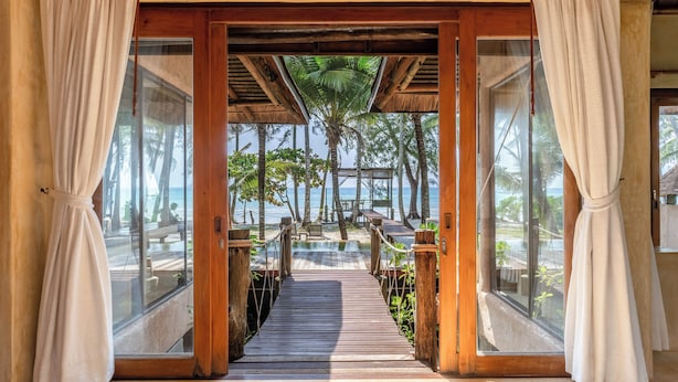 A wooden deck leading to a beach with palm trees and a view of the ocean. - High Season Pool Villa & Spa (Ko Kood)