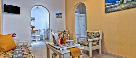 Un salón amplio con sofá, mesa de comedor y un cuadro en la pared.
