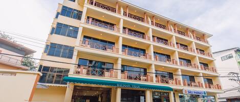 Un edificio de varios pisos con balcones, una farmacia y un letrero que dice "Bauman Village".