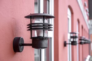 Outdoor wall-mounted lanterns on a building facade.