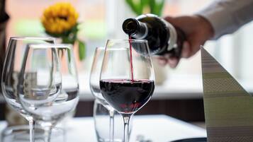 Una persona sirviendo vino tinto en una copa.