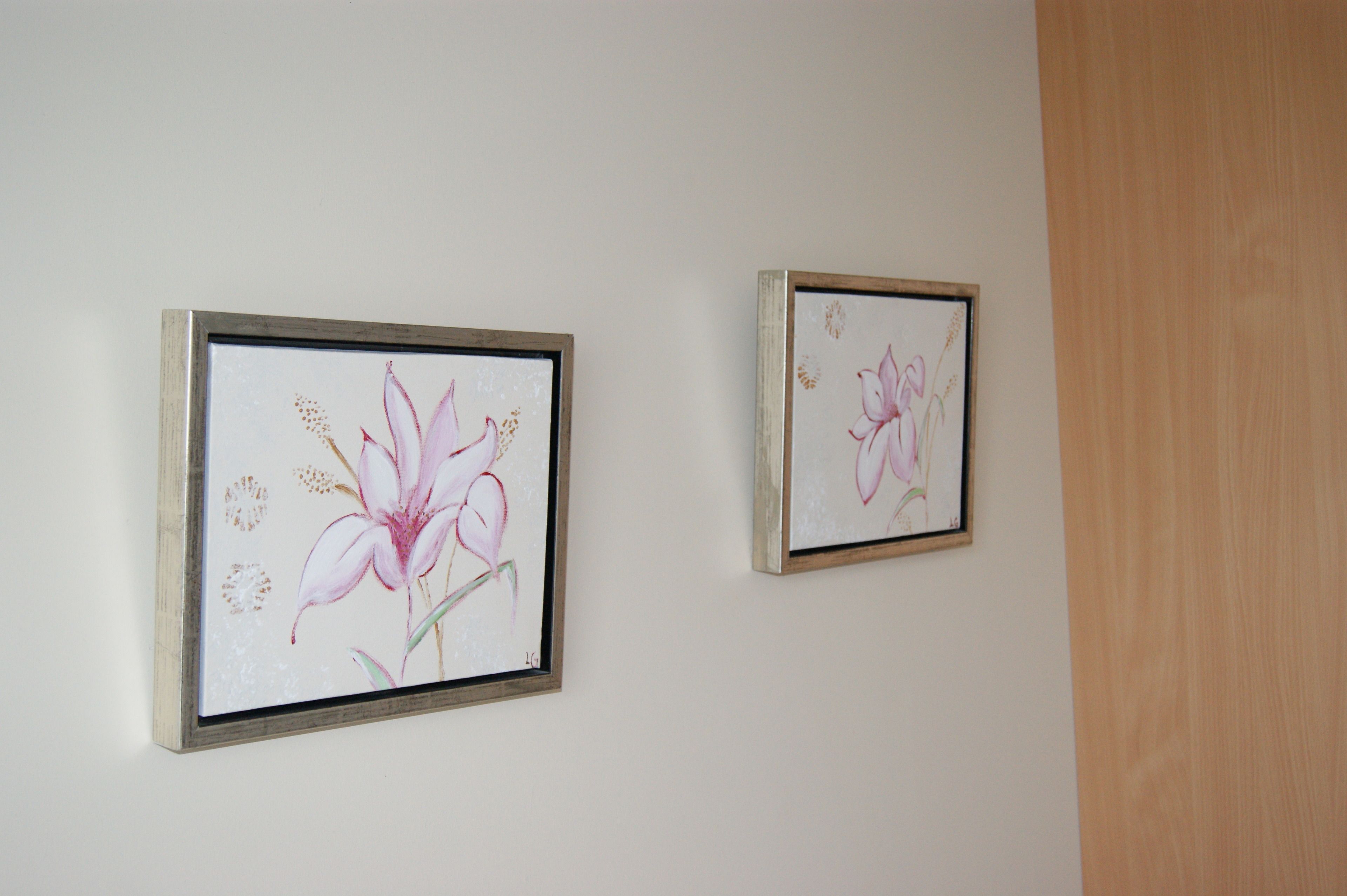 Two framed floral artworks on a plain wall.