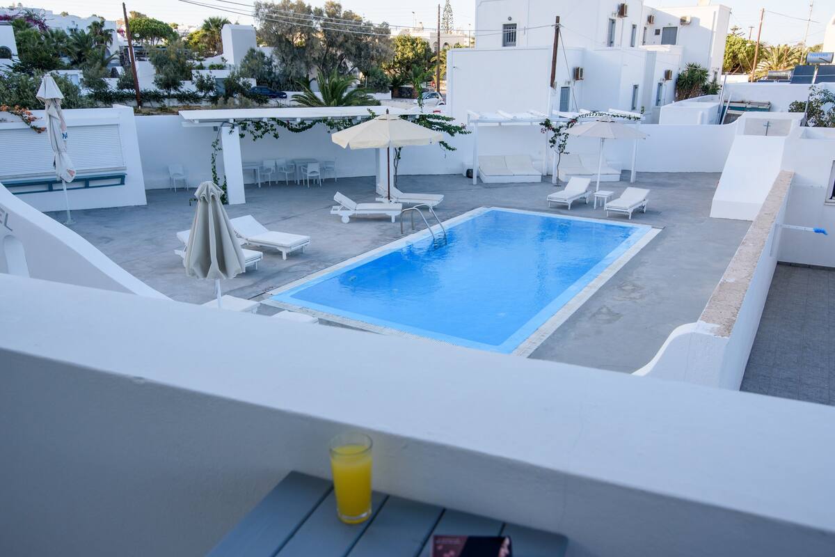 A rooftop pool area with lounge chairs and umbrellas.