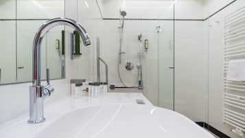 Un baño moderno con un lavabo blanco grande, grifería cromada y cabina de ducha de vidrio.