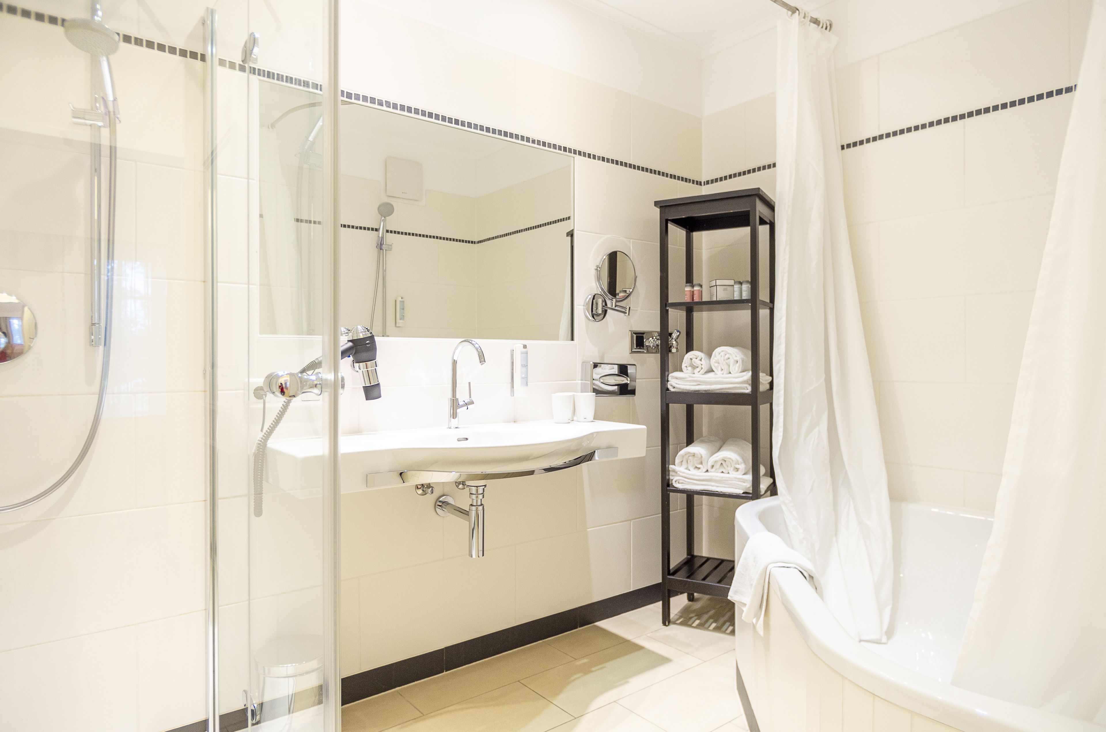 A modern bathroom with a glass-enclosed shower, a white sink, and a bathtub.