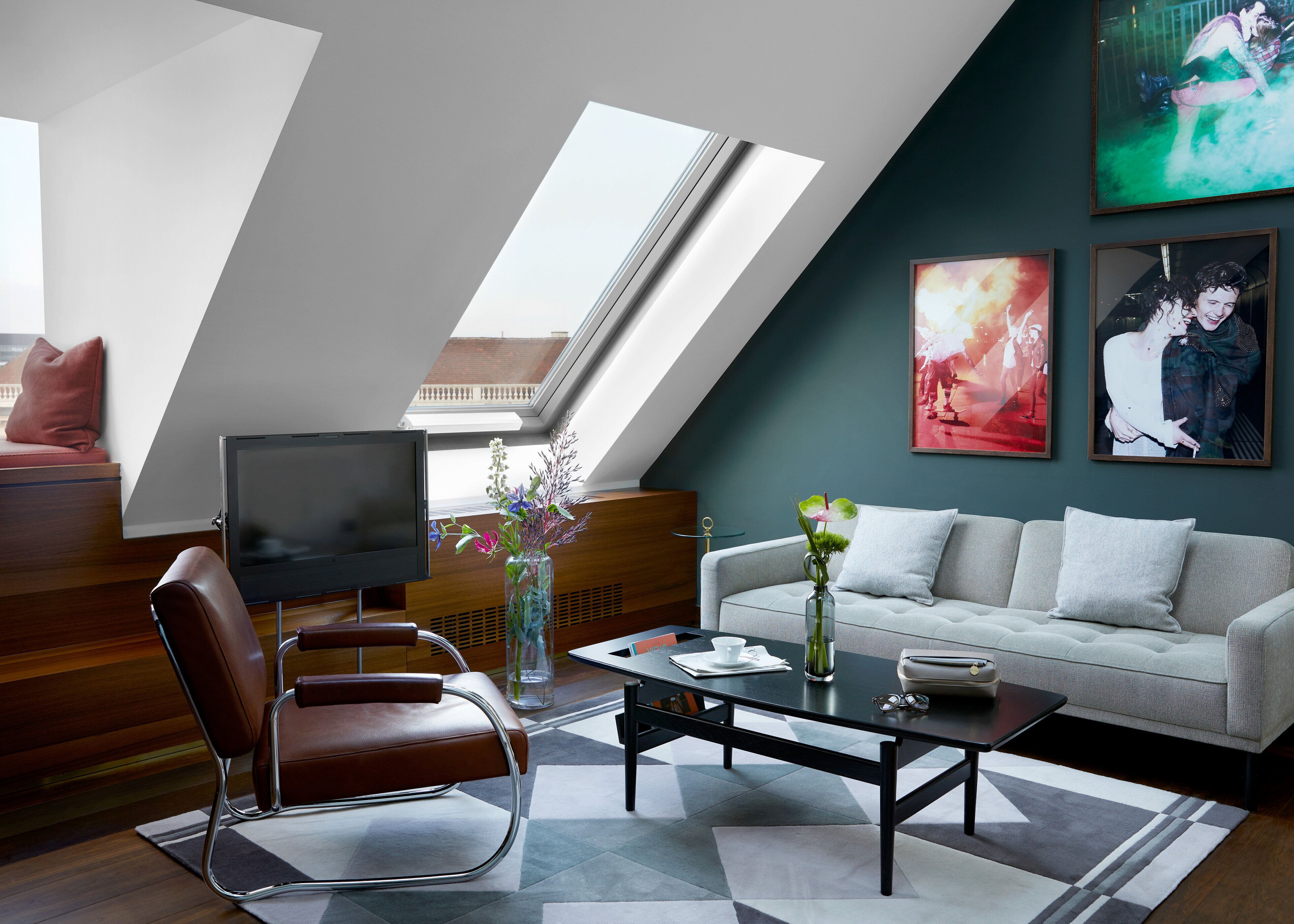 A modern living room with a sofa, a coffee table, a TV, and artwork on the walls.