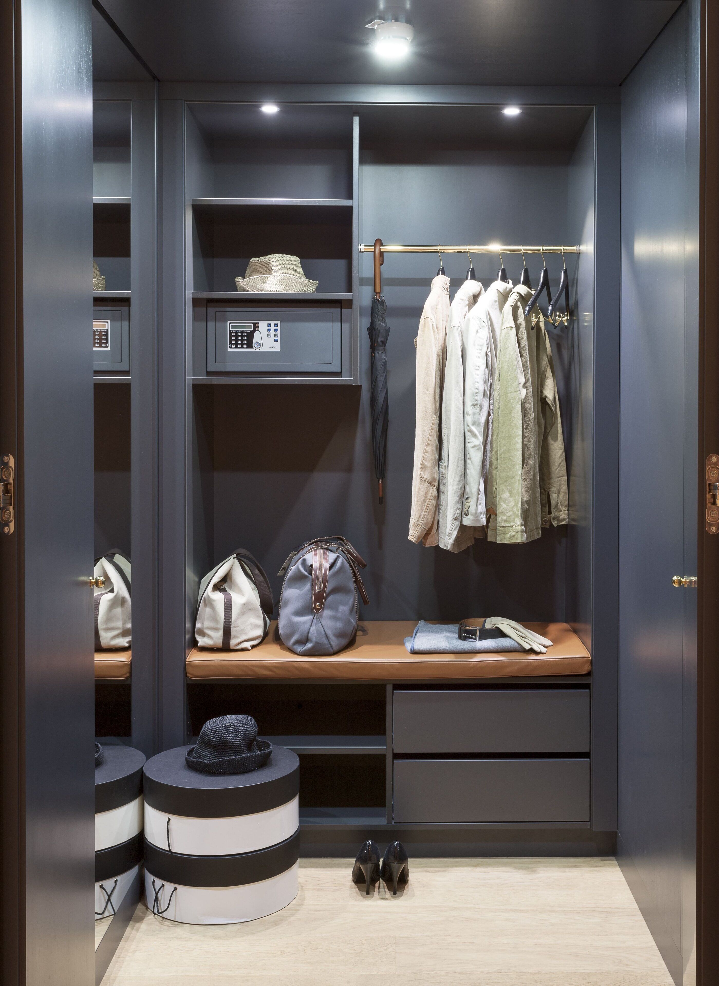 A walk-in closet with shelves, a bench, hanging clothes, and a shoe rack.