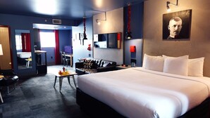 Een moderne hotelkamer met een groot bed, een bureau, een stoel, een bank en een spiegel.