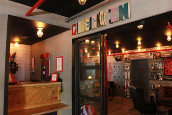 A room with a wooden wall, a couch, a table with a game, and lockers. at Hotel Gaythering - Gay Hotel - All Adults Welcome