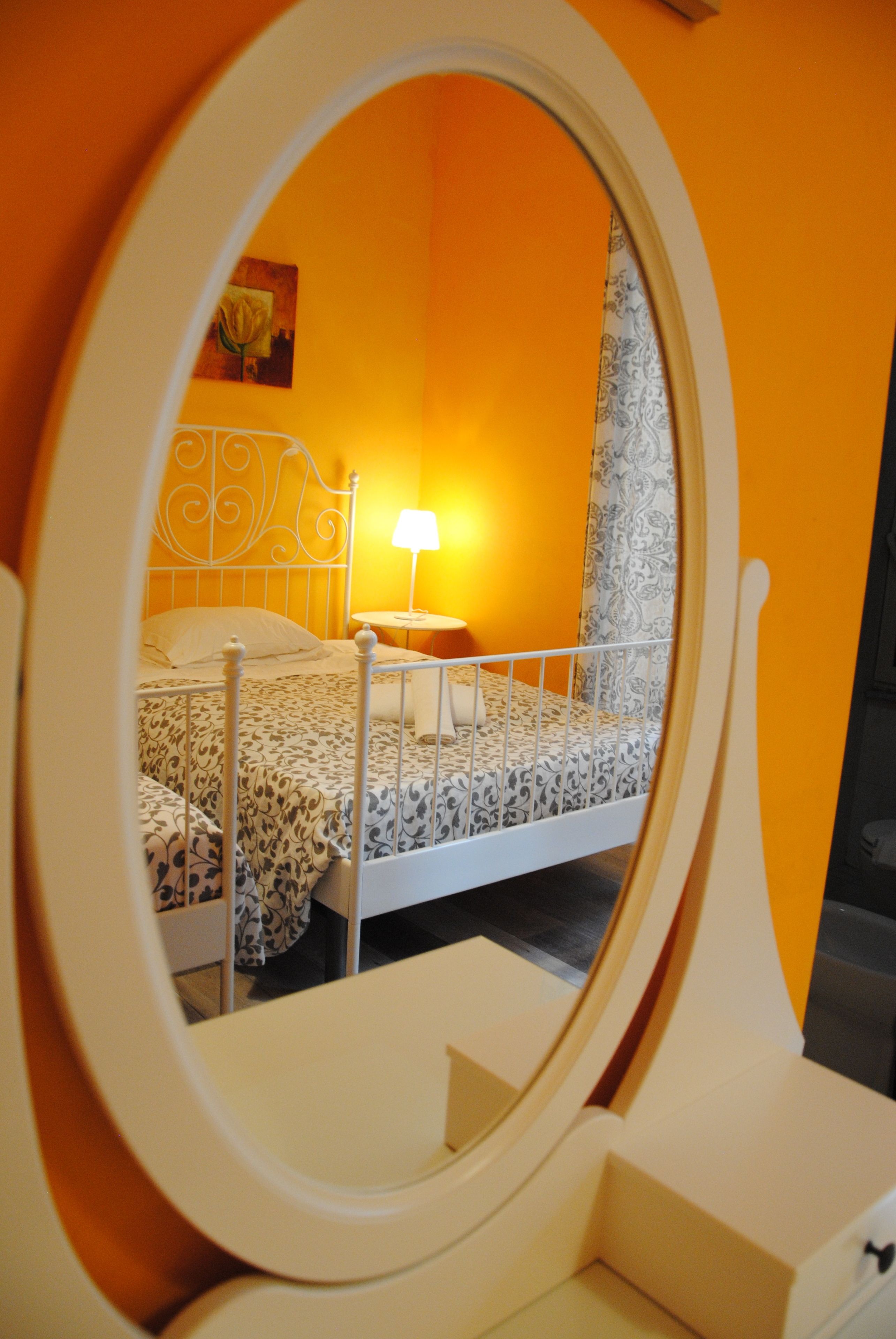 A bedroom with a bed, a bedside table, a lamp, and a painting on the wall.