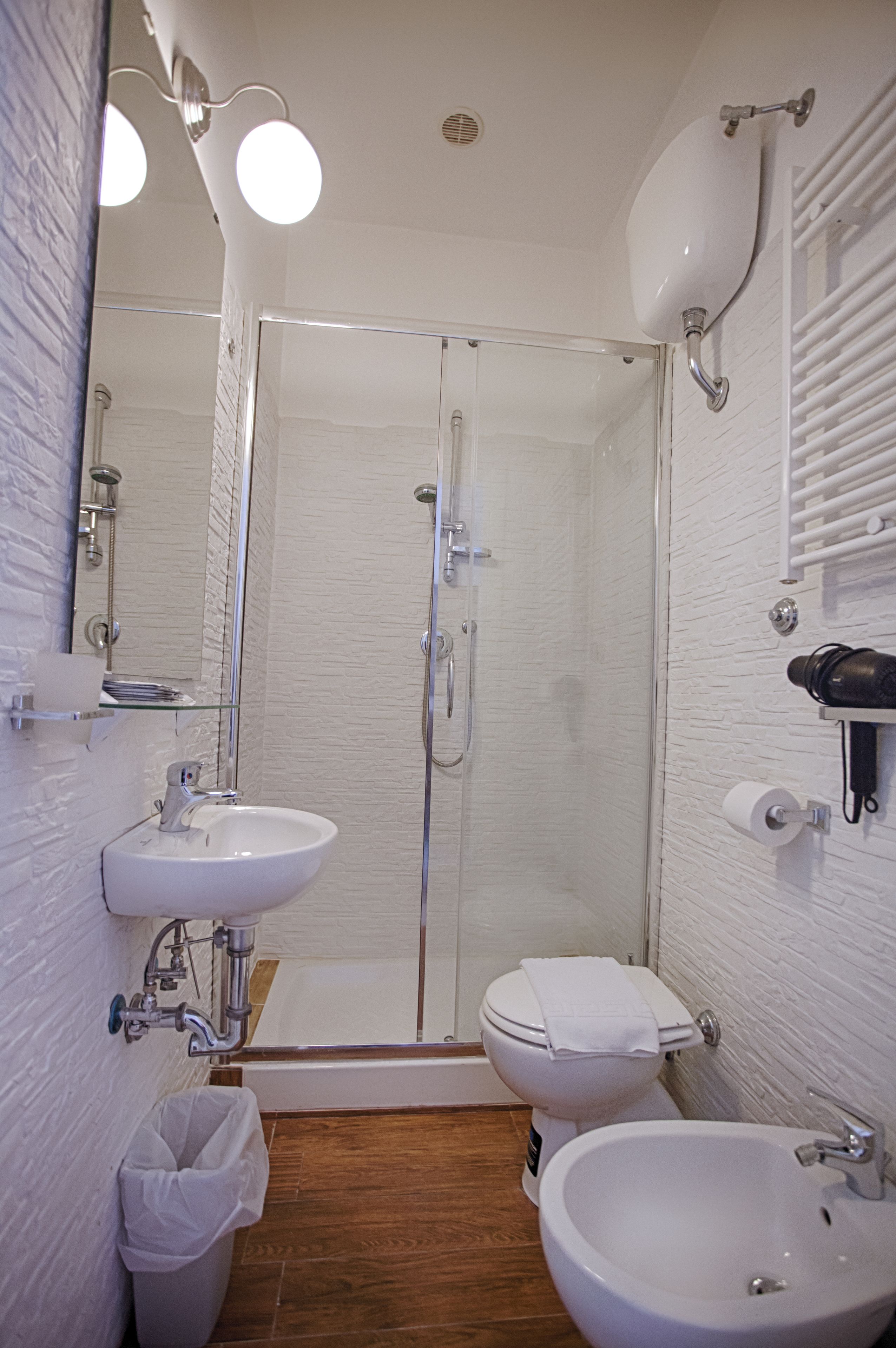 Ein modernes Badezimmer mit Duschkabine, zwei Waschbecken und Toilette.