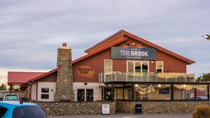 A building with a sign reading "The Brook Bar & Eatery" and a stone chimney. - The Riverstone (Rangiora)