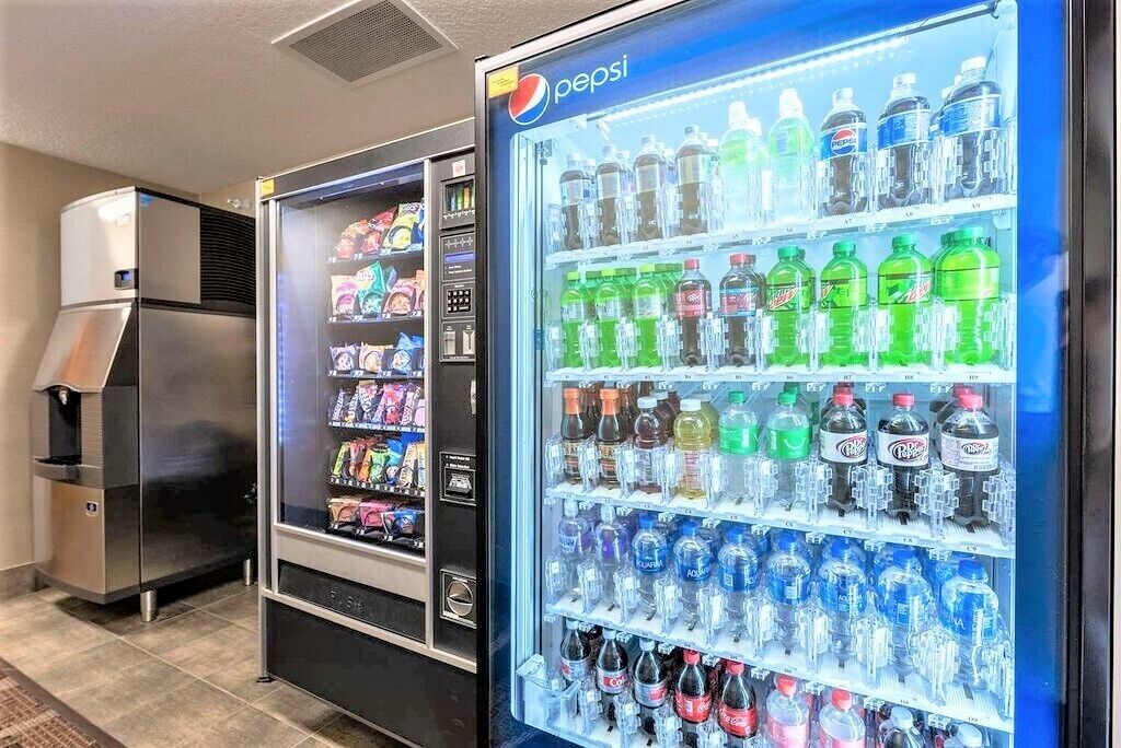 Una máquina expendedora con Pepsi y otras bebidas, además de una cafetera.