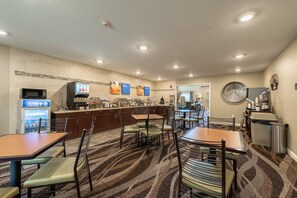 A restaurant with a counter, seating area, and a microwave.
