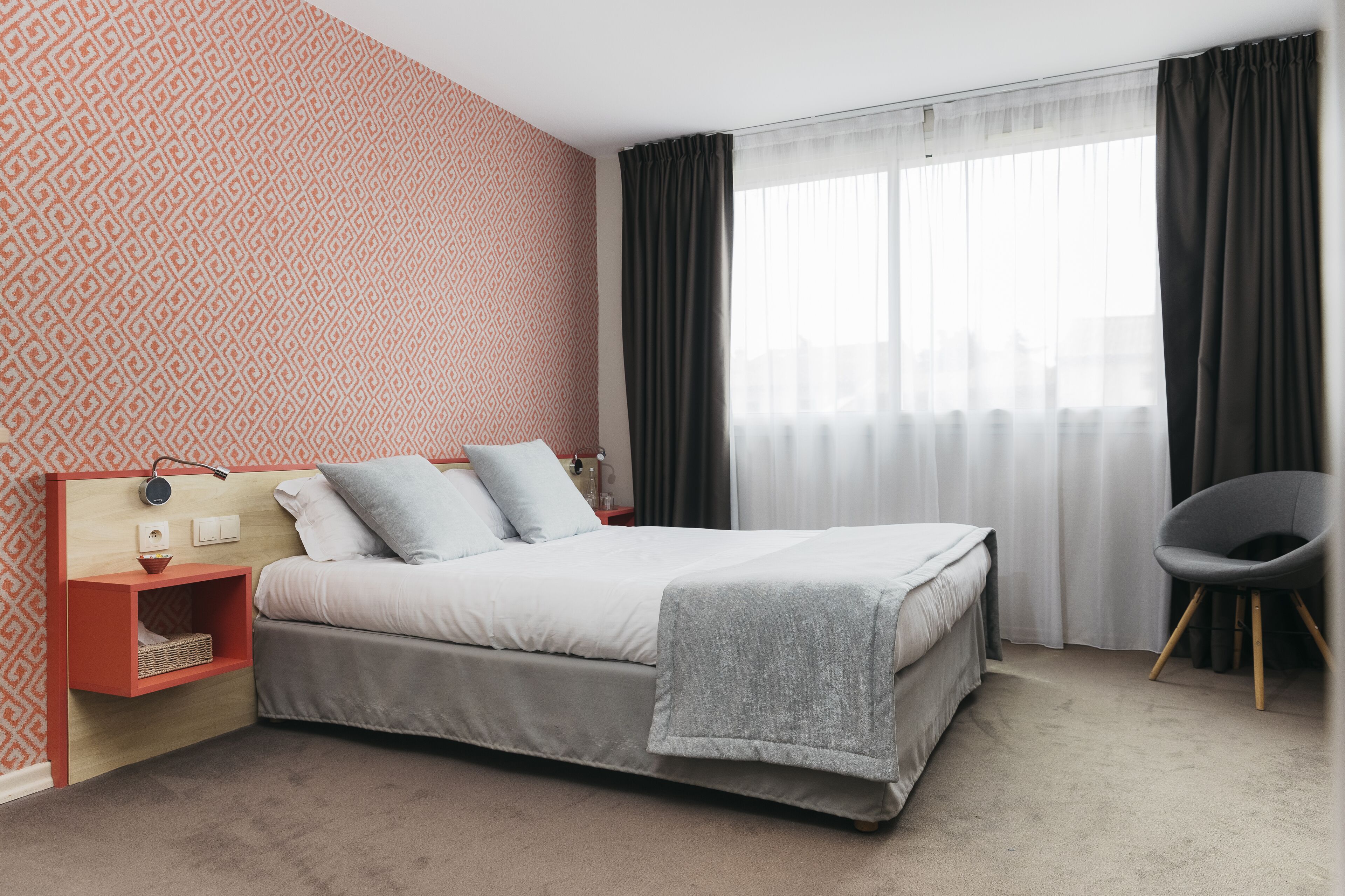 Une chambre à coucher moderne avec un lit, une table de chevet et une chaise.