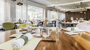 Un restaurant avec des tables en bois, de la vaisselle en verre transparente et un décor intérieur moderne.
