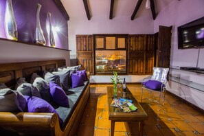 Relax in the stylish living area with a comfortable sofa, coffee table, and modern chair, offering a view of the city.