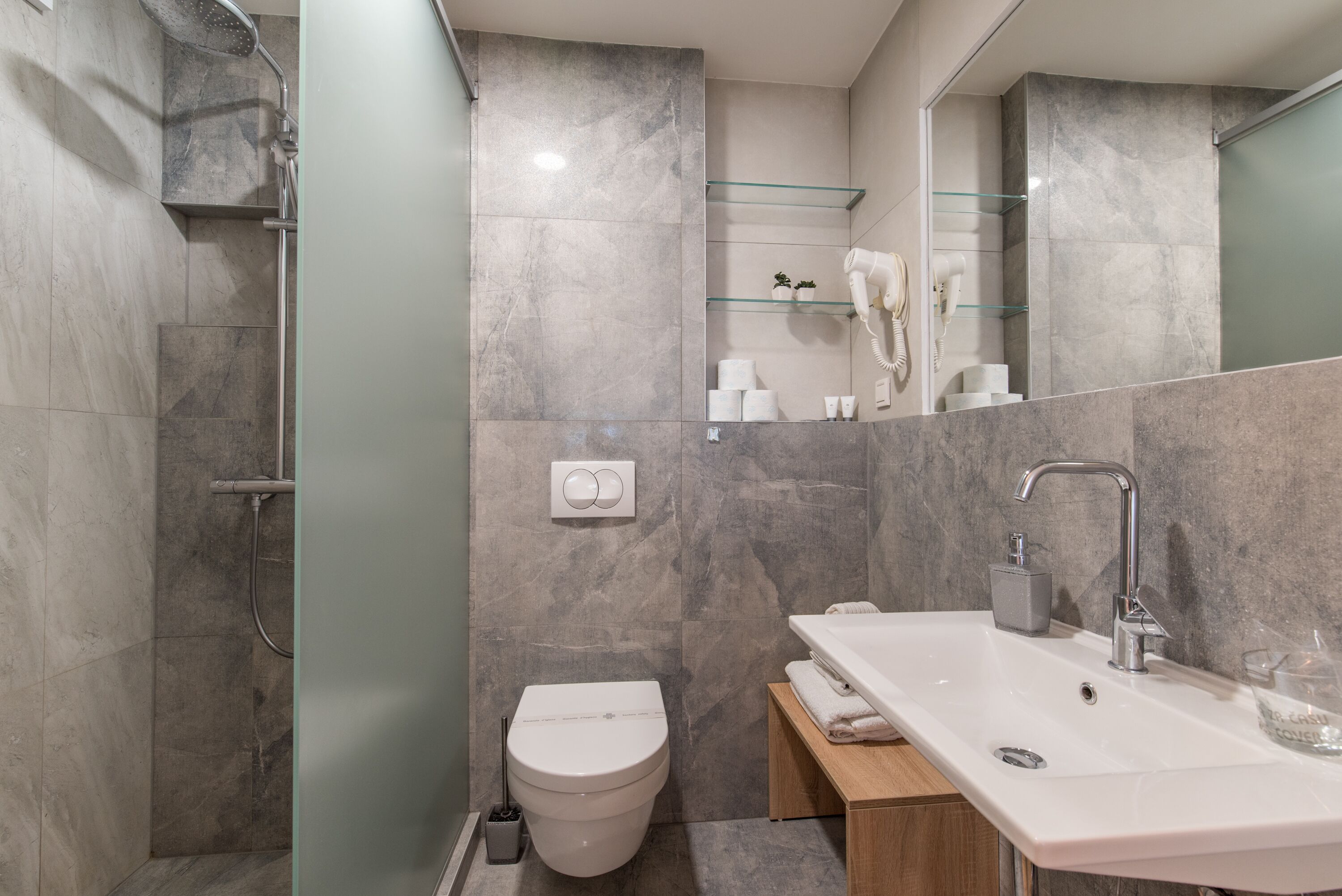 Ein modernes Badezimmer mit Dusche, Toilette und Waschbecken.