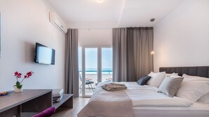 Et moderne hotelværelse med seng, skrivebord, fjernsyn og havudsigt.